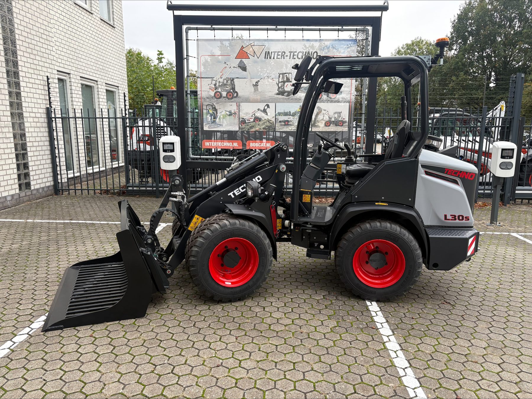 Techno L30s compacte wiellader, zijaanzicht links met bak